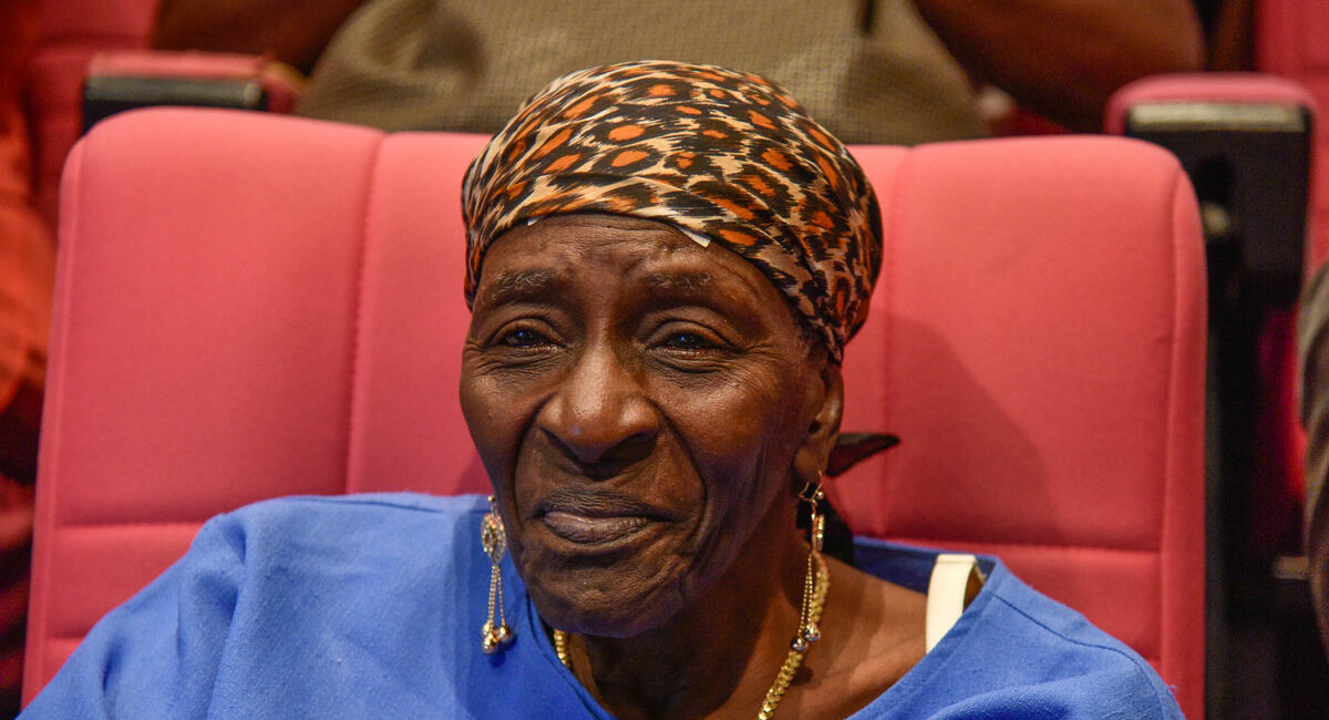 femme noire âgée et souriante participant à un débat public en guadeloupe